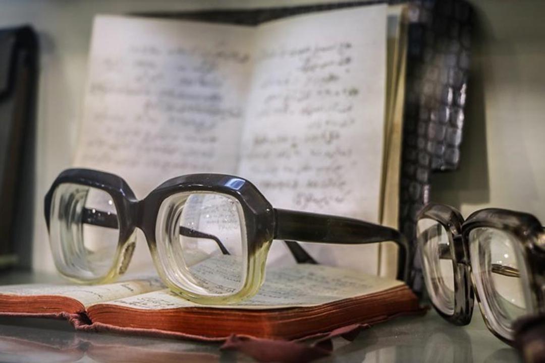 عینک گرد معروف، ساعت، قلمها و مدارک قدیمی دکتر محمود حسابی در ویترین موزه