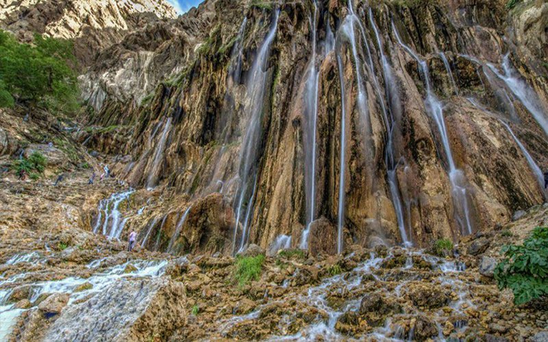 نمای نزدیک از ریزش قطرات آب از صخره‌های پوشیده از خزه‌ی آبشار مارگون
